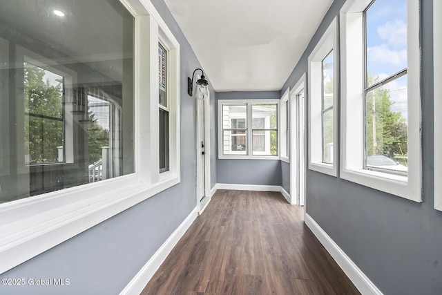 unfurnished sunroom featuring wood finished floors and baseboards