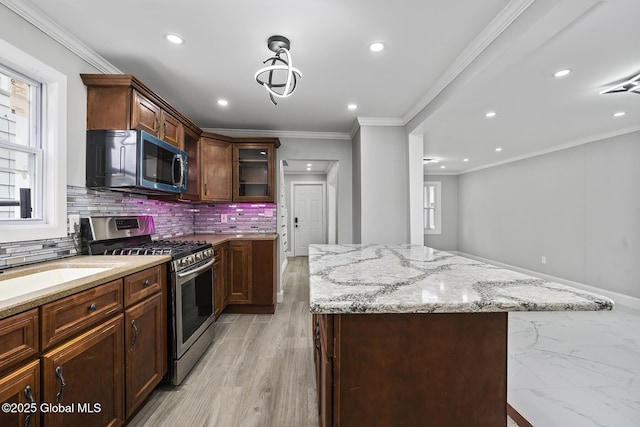 kitchen with stainless steel appliances, recessed lighting, light stone countertops, decorative backsplash, and a kitchen island