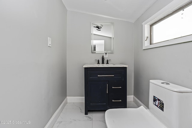 bathroom with marble finish flooring, toilet, baseboards, and vanity