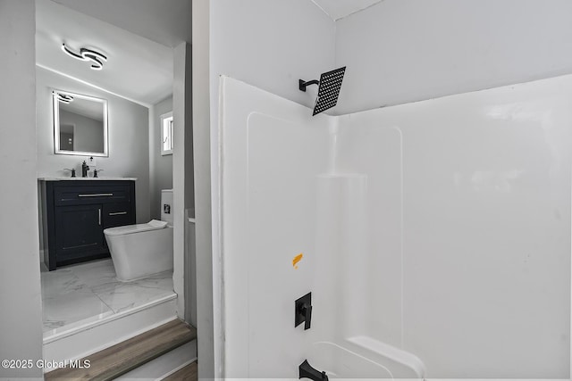 bathroom with toilet, a shower, vanity, and marble finish flooring