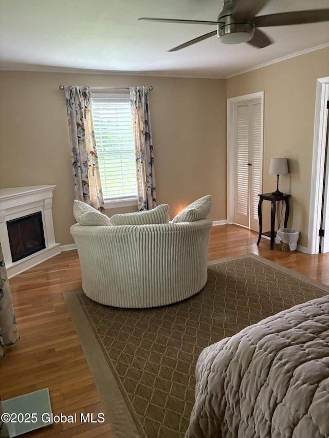 353 Truax Rd, Amsterdam, NY 12010 - living area featuring ceiling fan, crown molding, dark wood finished floors, a fireplace with raised hearth, and baseboards