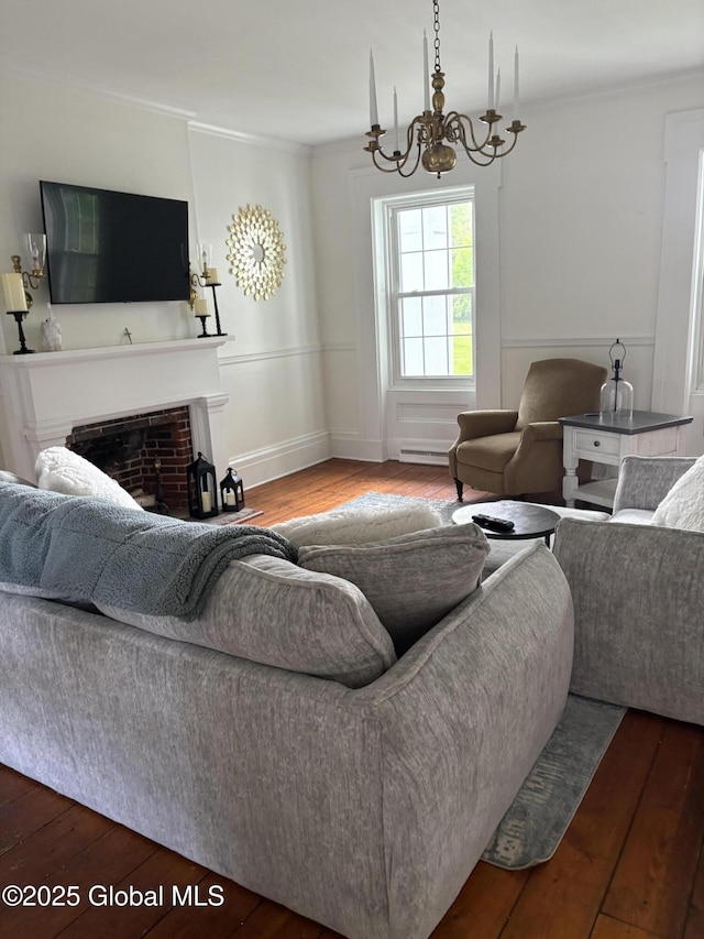 353 Truax Rd, Amsterdam, NY 12010 - living area featuring wood finished floors, ornamental molding, a chandelier, a fireplace, and a baseboard heating unit