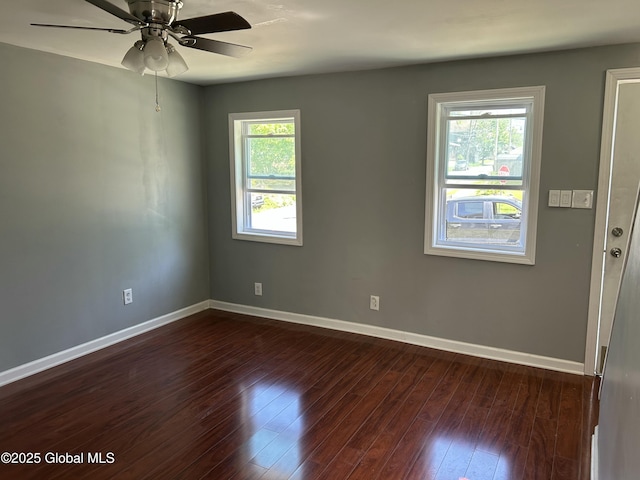 empty room featuring baseboards, dark wood-type flooring, and ceiling fan