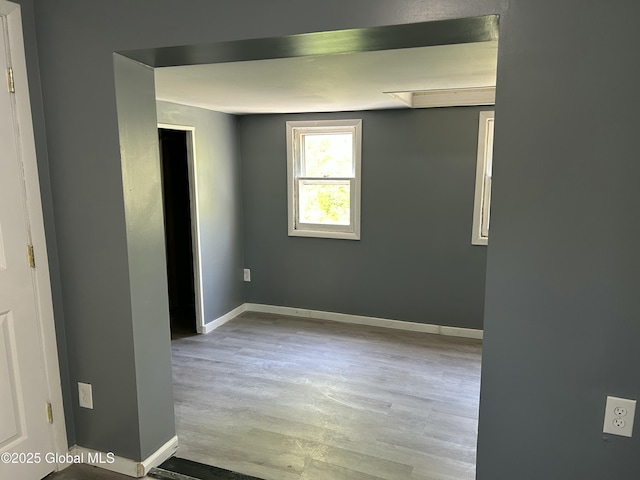 spare room featuring wood finished floors and baseboards