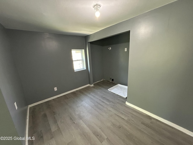 spare room with wood finished floors and baseboards