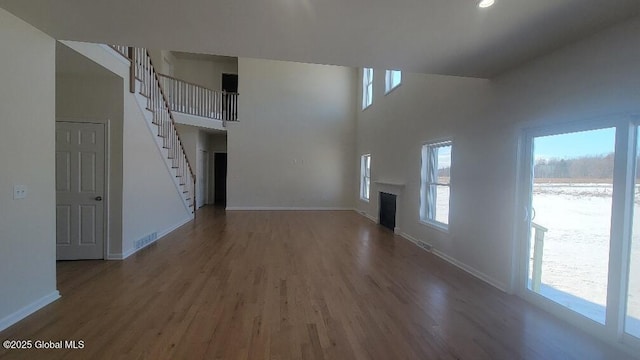 35 Sally St, Halfmoon, NY 12118 - unfurnished living room featuring healthy amount of natural light, wood finished floors, baseboards, and a high ceiling
