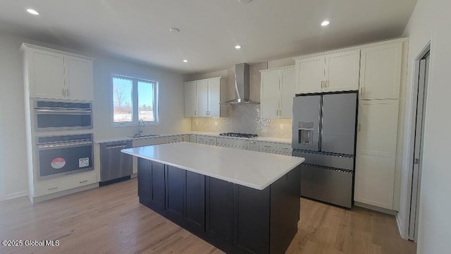 35 Sally St, Halfmoon, NY 12118 - kitchen with wall chimney range hood, stainless steel appliances, a kitchen island, light countertops, and white cabinetry