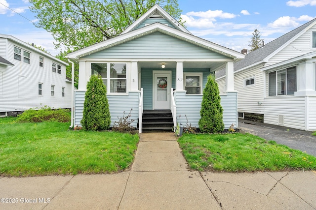 shotgun-style home featuring a front lawn and a porch