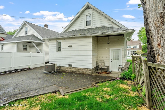 back of house with a patio, central AC, fence, and roof with shingles