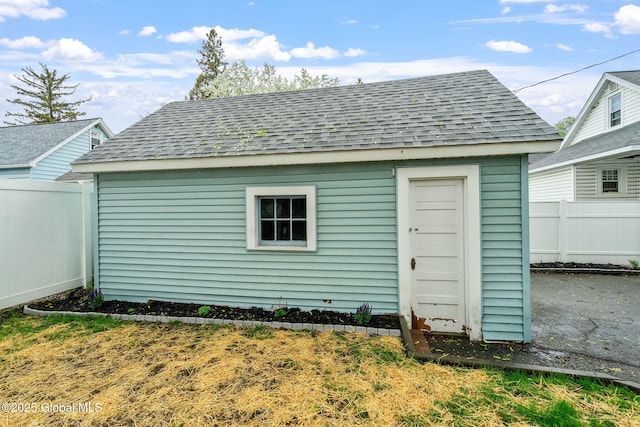 view of outdoor structure featuring fence and an outbuilding
