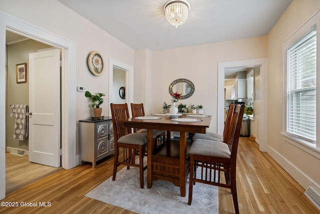 dining space with light wood finished floors, healthy amount of natural light, and baseboards