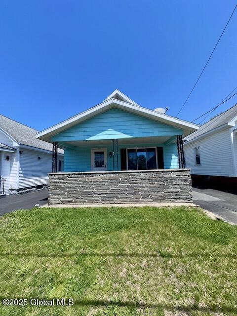 view of front of home with a porch and a front lawn