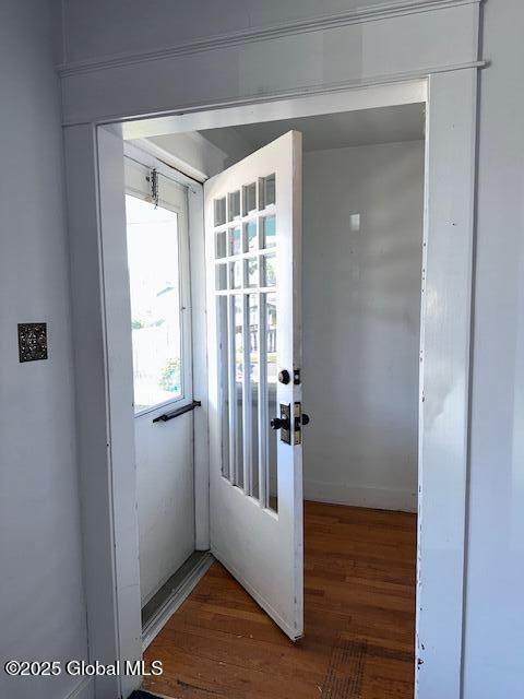 doorway to outside featuring wood finished floors and baseboards
