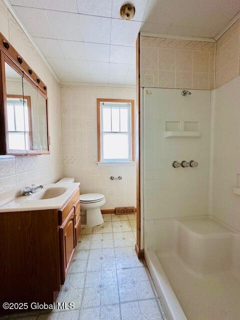 bathroom with a stall shower, vanity, tile patterned floors, and toilet