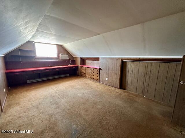 bonus room with vaulted ceiling, carpet flooring, baseboard heating, wood walls, and a wall unit AC