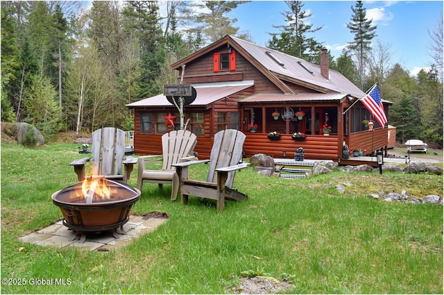 152 Sweenie Fields Rd, Schroon Lake, NY 12870 - back of house featuring a fire pit, a chimney, metal roof, and a yard