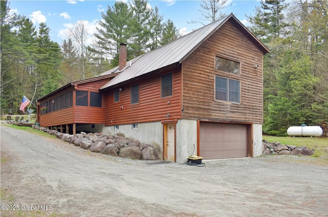 152 Sweenie Fields Rd, Schroon Lake, NY 12870 - view of side of property with a garage, driveway, a chimney, metal roof, and a sunroom