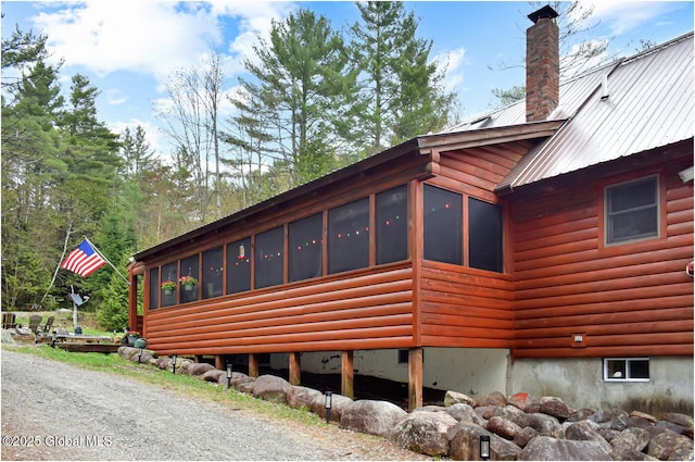 152 Sweenie Fields Rd, Schroon Lake, NY 12870 - view of home's exterior featuring a sunroom, a chimney, faux log siding, and metal roof