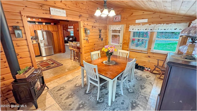 152 Sweenie Fields Rd, Schroon Lake, NY 12870 - dining area featuring a wood stove, vaulted ceiling, wooden walls, a chandelier, and wood ceiling