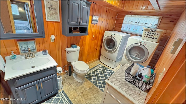 152 Sweenie Fields Rd, Schroon Lake, NY 12870 - bathroom with washing machine and clothes dryer, wood walls, baseboards, toilet, and vanity
