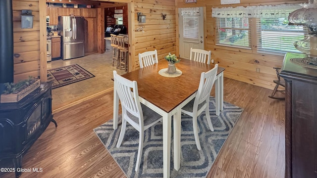 152 Sweenie Fields Rd, Schroon Lake, NY 12870 - dining area featuring a wood stove, wood walls, and light wood-style floors