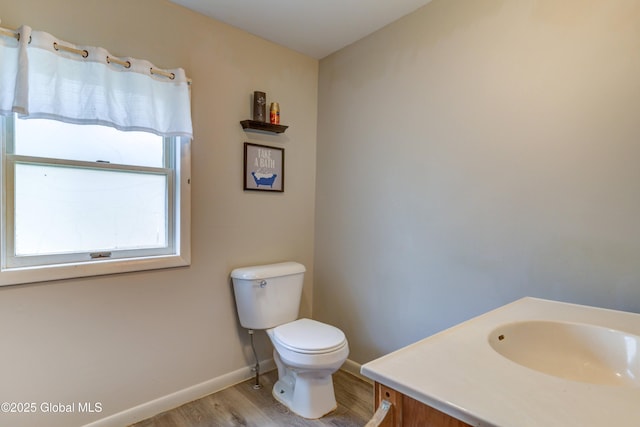 6 William St, Gloversville, NY 12078 - bathroom featuring wood finished floors, toilet, baseboards, and vanity