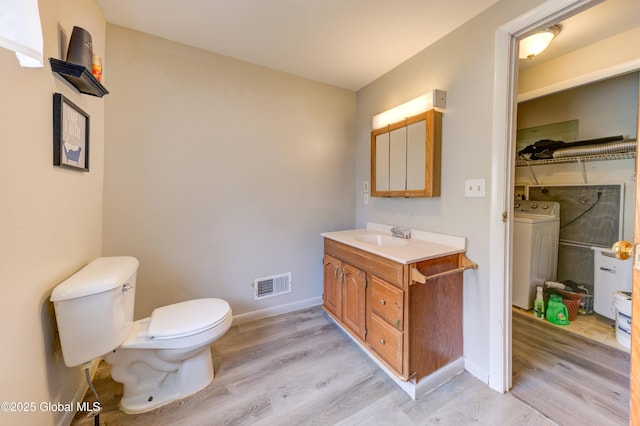 6 William St, Gloversville, NY 12078 - bathroom featuring washer / dryer, wood finished floors, toilet, vanity, and baseboards