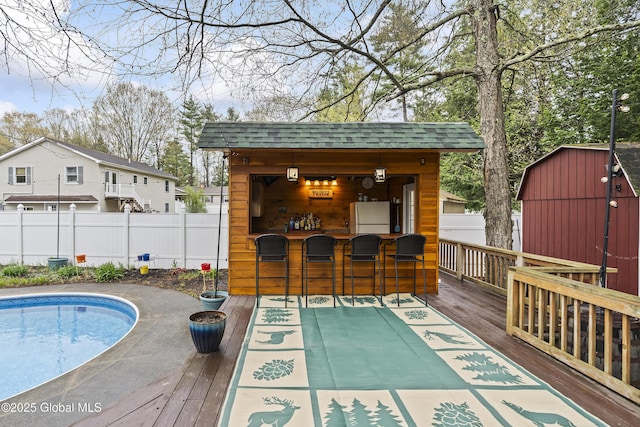 19 Karen St, Warrensburg, NY 12885 - view of swimming pool with fence, an outdoor structure, a wooden deck, and a storage shed