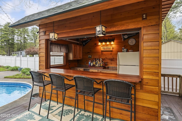 19 Karen St, Warrensburg, NY 12885 - indoor bar featuring freestanding refrigerator, wood walls, wood-type flooring, and hanging light fixtures
