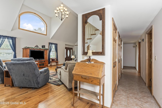 19 Karen St, Warrensburg, NY 12885 - living room featuring plenty of natural light, high vaulted ceiling, a chandelier, and light wood-style floors