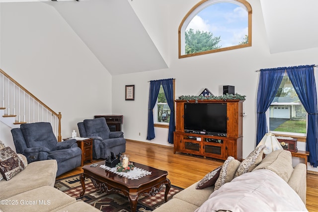 19 Karen St, Warrensburg, NY 12885 - living area featuring high vaulted ceiling, wood finished floors, healthy amount of natural light, and stairway
