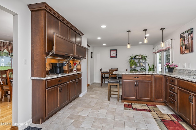 19 Karen St, Warrensburg, NY 12885 - kitchen with a peninsula, recessed lighting, light stone counters, hanging light fixtures, and a breakfast bar area