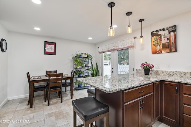 19 Karen St, Warrensburg, NY 12885 - kitchen with light stone counters, a peninsula, decorative light fixtures, recessed lighting, and baseboards