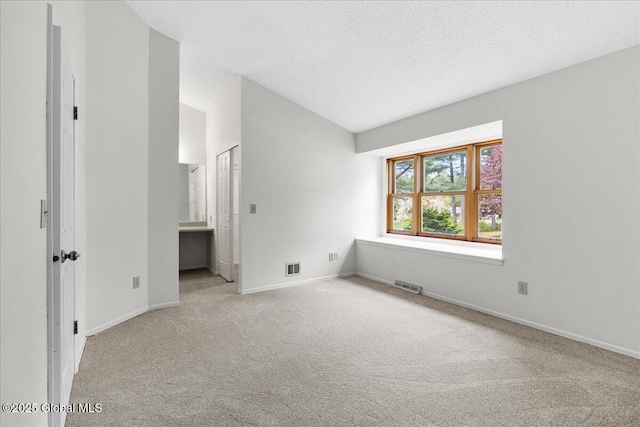 10 Tiffany Dr, Queensbury, NY 12804 - carpeted spare room featuring vaulted ceiling, baseboards, and a textured ceiling