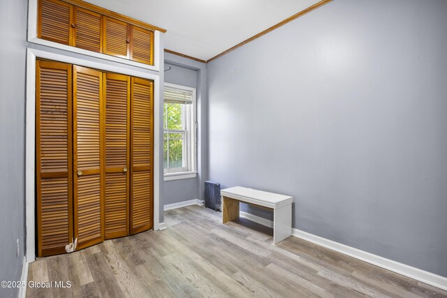 9 Archibald St, Colonie, NY 12189 - unfurnished bedroom with wood finished floors, a closet, baseboards, ornamental molding, and radiator