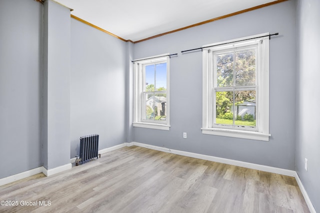 9 Archibald St, Colonie, NY 12189 - empty room featuring radiator heating unit, crown molding, plenty of natural light, wood finished floors, and baseboards