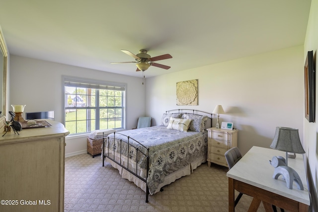 bedroom featuring light colored carpet, baseboards, and a ceiling fan
