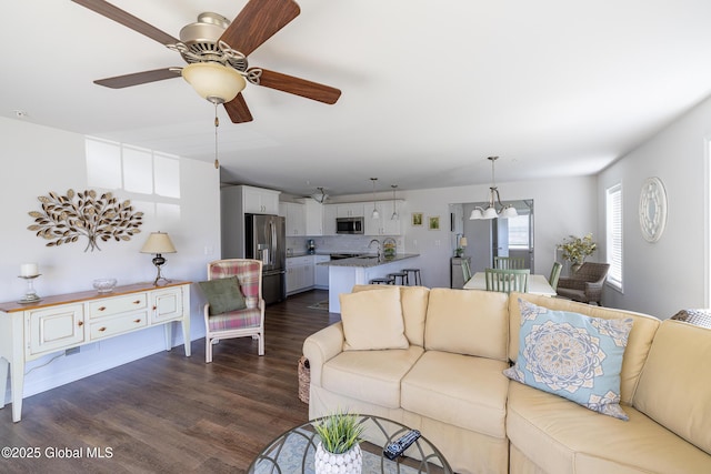 living room featuring dark wood-type flooring and ceiling fan