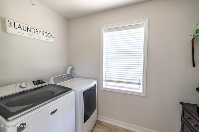 clothes washing area featuring washer and clothes dryer and baseboards