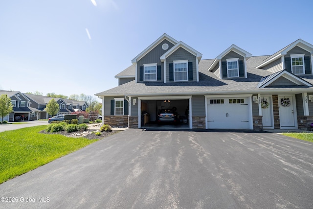 view of front of house with asphalt driveway, stone siding, and a shingled roof