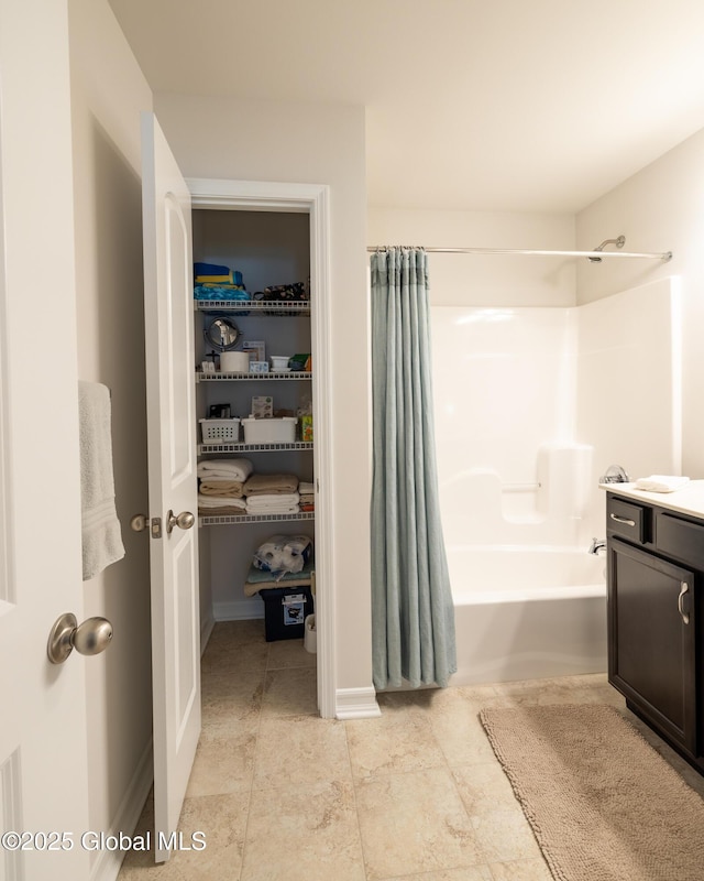 bathroom with shower / tub combo, vanity, and baseboards