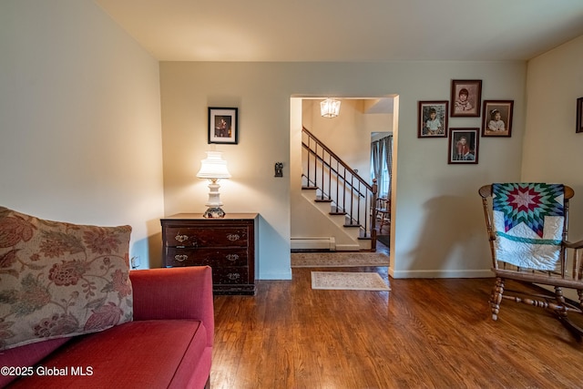 76 Mcnutt Ave, Colonie, NY 12205 - living area with a baseboard radiator, wood finished floors, stairway, and baseboards
