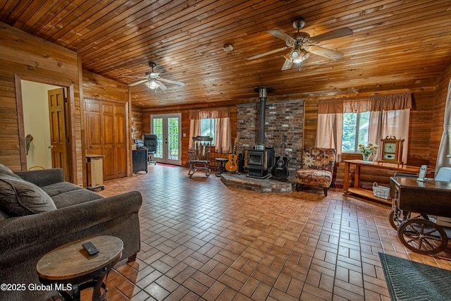 76 Mcnutt Ave, Colonie, NY 12205 - living area featuring ceiling fan, wooden walls, a wood stove, plenty of natural light, and wooden ceiling