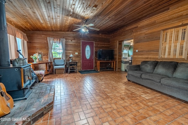 76 Mcnutt Ave, Colonie, NY 12205 - living area with a wood stove, wooden walls, ceiling fan, and brick patterned flooring
