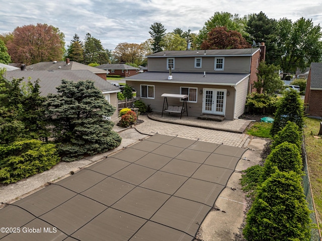 76 Mcnutt Ave, Colonie, NY 12205 - rear view of property with french doors, a patio area, and a chimney
