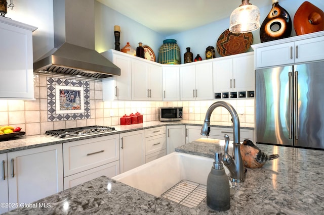 49 N Village Cir, Round Lake, NY 12151 - kitchen featuring wall chimney range hood, appliances with stainless steel finishes, white cabinetry, and decorative backsplash