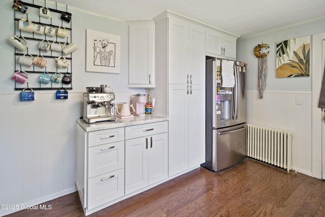 kitchen featuring radiator, stainless steel fridge, light countertops, dark wood-style floors, and white cabinetry