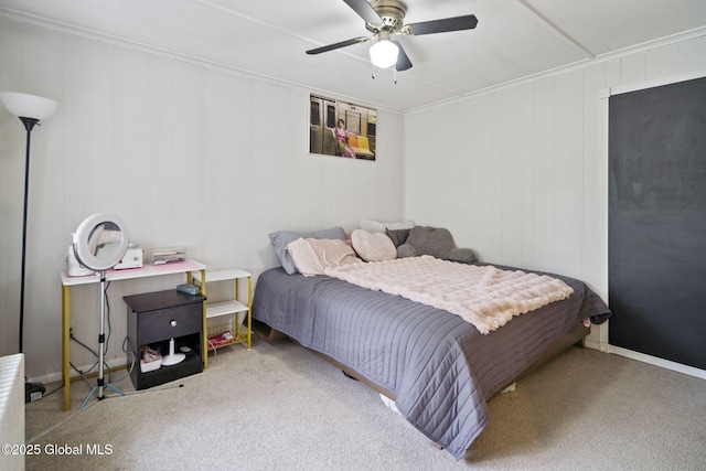 carpeted bedroom with ceiling fan, crown molding, and baseboards