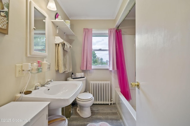 bathroom featuring radiator, toilet, crown molding, wood finished floors, and shower / tub combo