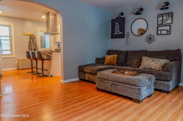 3001 Evelyn Dr, Guilderland, NY 12303 - living room with arched walkways, radiator, light wood finished floors, baseboards, and recessed lighting